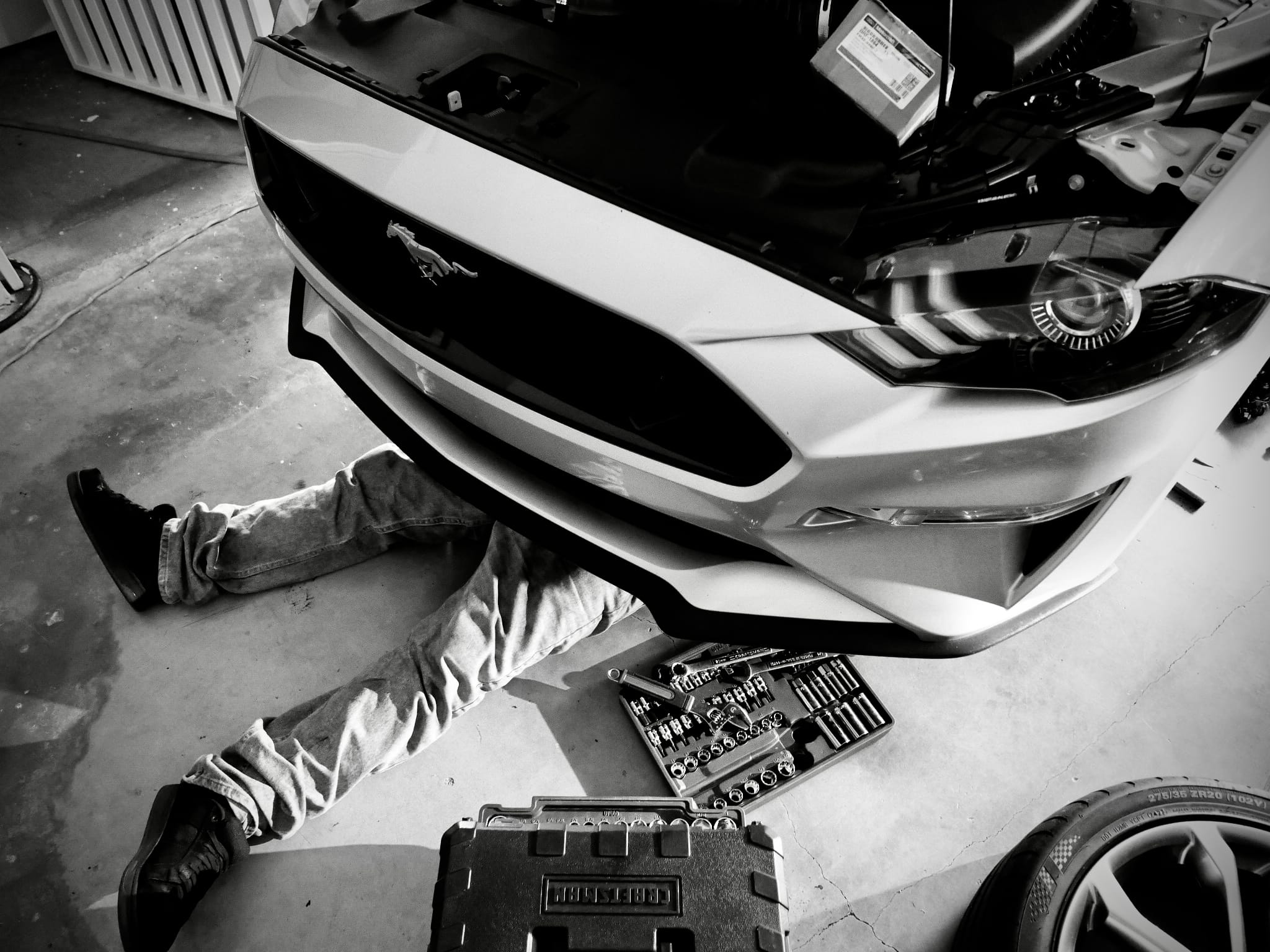 Mecánico trabajando bajo un Mustang